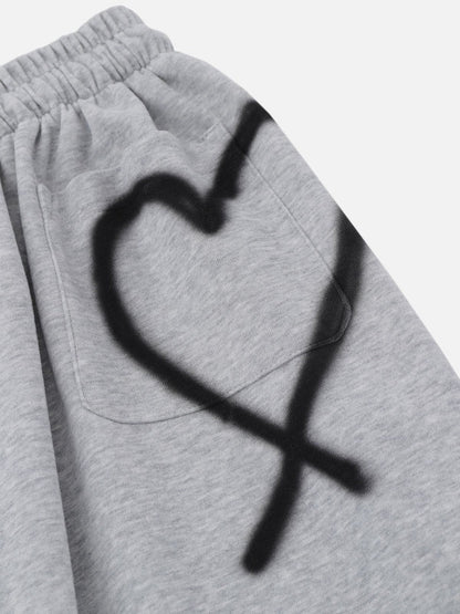 Pantalones deportivos holgados con corazon de grafiti